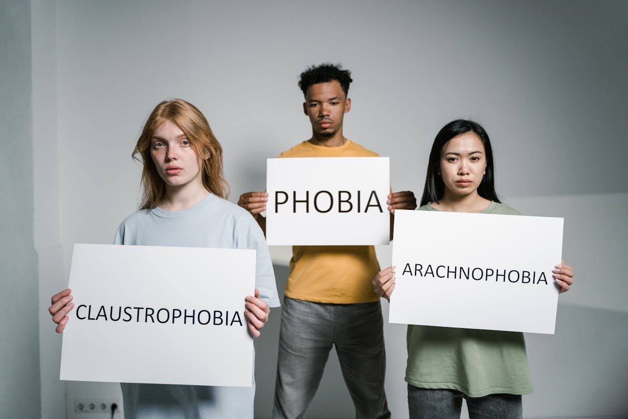 about-01 Three individuals demonstrate common phobias: arachnophobia, claustrophobia, and general fear.