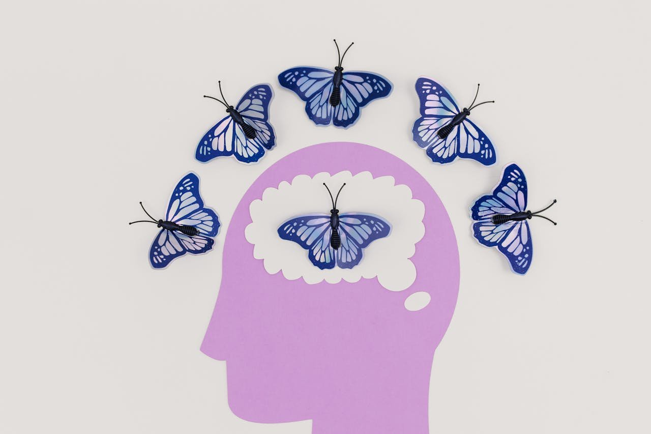 services-01 Creative illustration of butterflies representing thoughts over a brain silhouette.